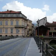 Ponte acciottolato a Garessio, con edifici storici e la torre dell'orologio che svetta. L'altitudine di Garessio offre scorci suggestivi.