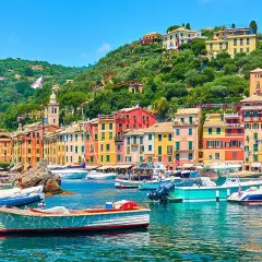 Portofino cosa vedere: case colorate, barche nel porto e colline verdi. Un incanto ligure.