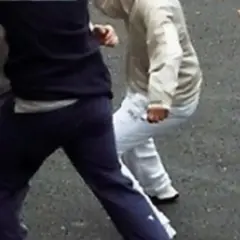Un gruppo di ragazzi è coinvolto in una rissa a scuola. Si vedono pugni e corpi in movimento.