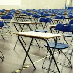 File di sedie e banchi vuoti in un'aula, pronti per le nuove classi di concorso.