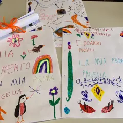 Disegni e scritte a mano, tra cui "Mia Pagella" e l'alfabeto, mostrano i voti elementari di bambini.
