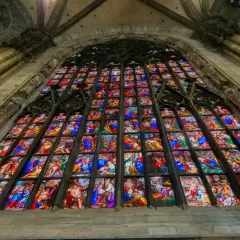 Le vetrate del Duomo di Milano narrano storie sacre con colori vibranti, un capolavoro di arte gotica che illumina l'interno.