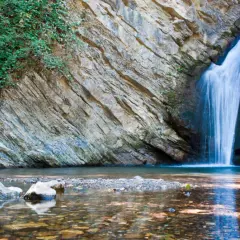 Cascate in Basilicata: acqua cristallina scende da rocce stratificate, circondate da vegetazione lussureggiante. Un angolo di paradiso naturale.