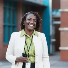 Donna sorridente con un walkie-talkie, pronta per il suo lavoro. Il suo dsga stipendio è meritato.