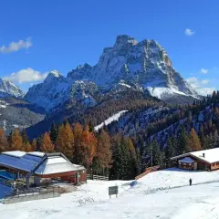 Paesaggio invernale con montagne innevate, boschi di larici e abeti, rifugi e un impianto di risalita. Ideale per il trekking in Cadore.