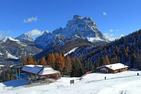 Paesaggio invernale con montagne innevate, boschi di larici e abeti, rifugi e un impianto di risalita. Ideale per il trekking in Cadore.
