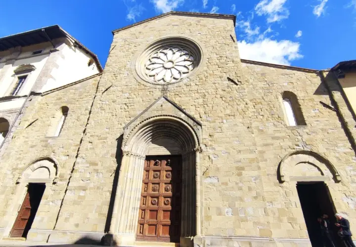 Facciata romanica del San Sepolcro, con rosone e portale in pietra.