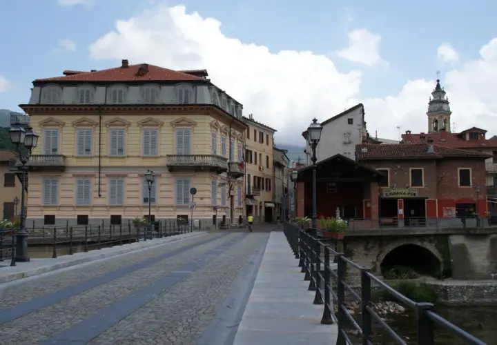 Ponte acciottolato a Garessio, con edifici storici e la torre dell'orologio che svetta. L'altitudine di Garessio offre scorci suggestivi.