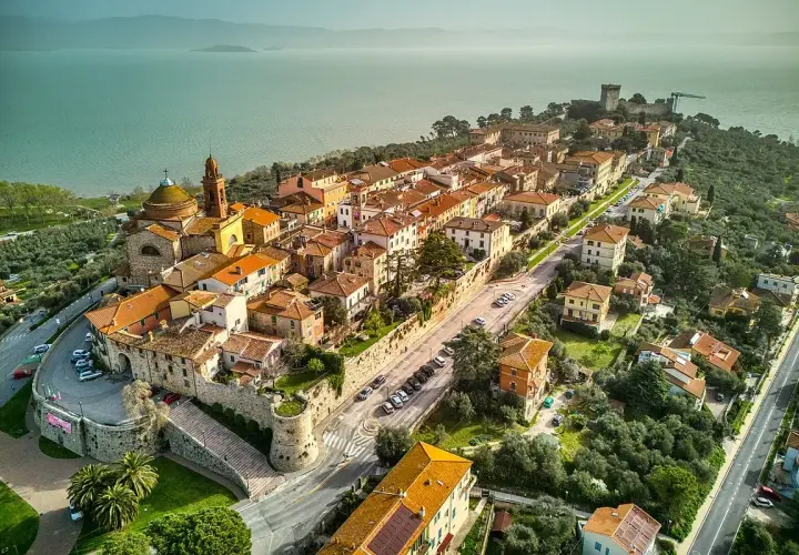 Vista aerea di Castiglione del Lago, un borgo medievale con tetti arancioni affacciato sul lago Trasimeno.