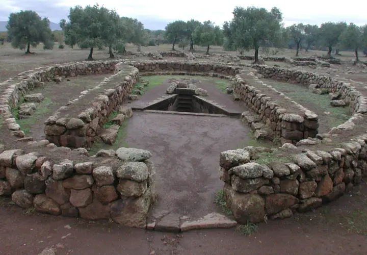 Antichi pozzi sacri in Sardegna, con mura in pietra a secco e una scala che scende nell'acqua.