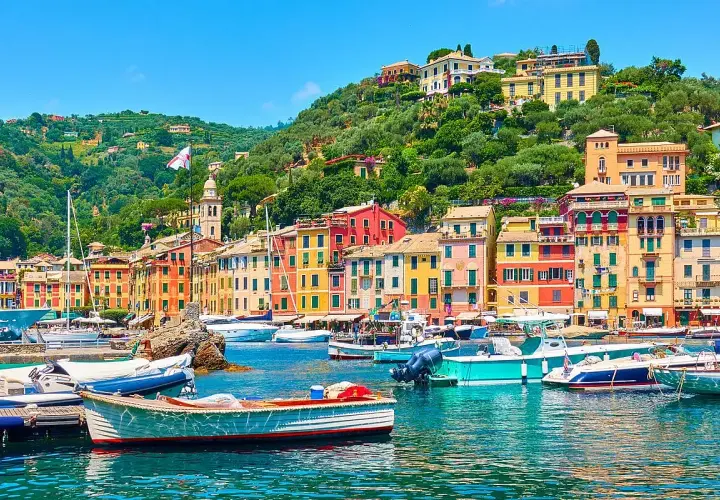 Portofino cosa vedere: case colorate, barche nel porto e colline verdi. Un incanto ligure.