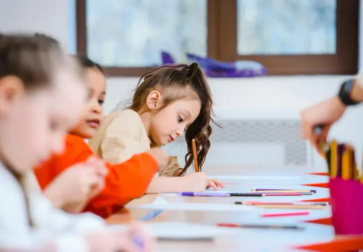 Bambini concentrati a disegnare, un esempio di scuola senza zaino pro e contro.