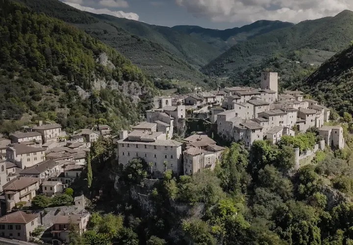 Borgo medievale di Arrone, Terni, incastonato tra verdi colline. Case in pietra e un'antica torre dominano il paesaggio.