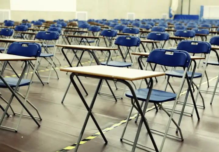 File di sedie e banchi vuoti in un'aula, pronti per le nuove classi di concorso.