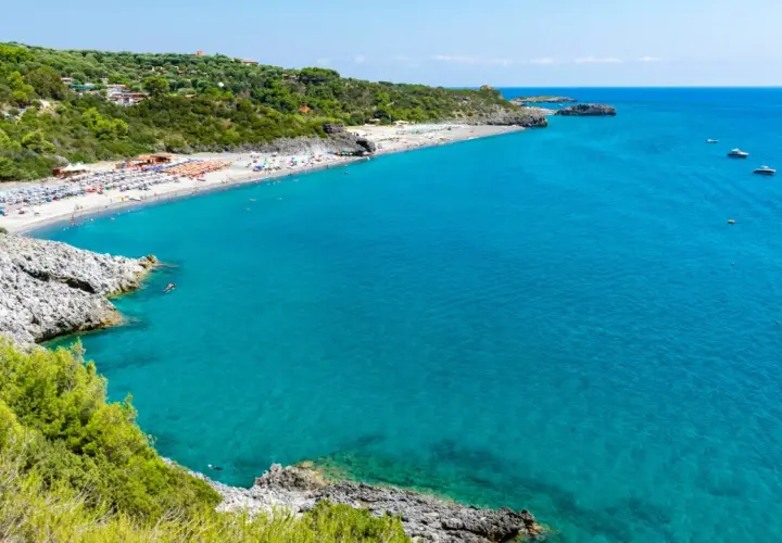 La spiaggia di Marina di Camerota, con il suo mare cristallino e la costa verdeggiante, invita al relax e al nuoto.