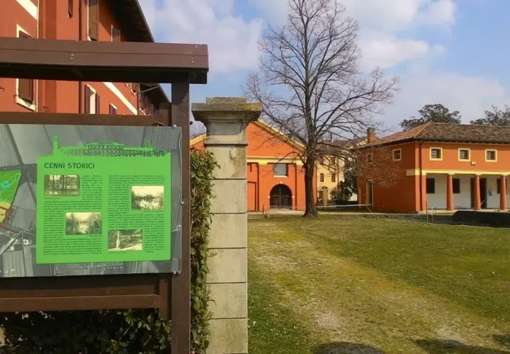 Cartello informativo sui cenni storici di Fossalta di Portogruaro, con edifici storici sullo sfondo.