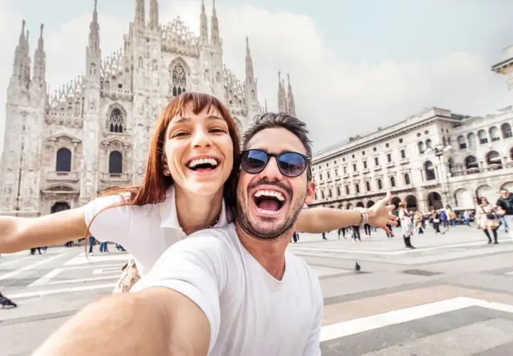 Coppia felice scatta un selfie a Milano, con il Duomo sullo sfondo. Perfetto per chi cerca visite guidate gratuite a Milano!