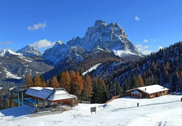 Paesaggio invernale con montagne innevate, boschi di larici e abeti, rifugi e un impianto di risalita. Ideale per il trekking in Cadore.