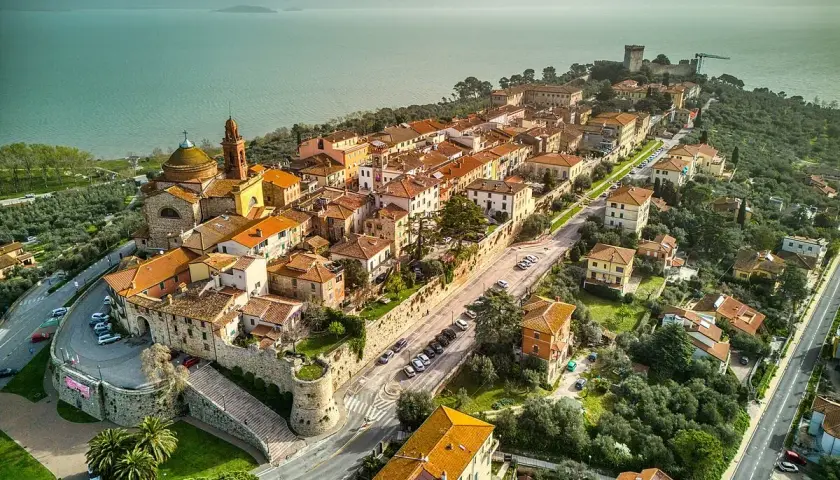 Vista aerea di Castiglione del Lago, un borgo medievale con tetti arancioni affacciato sul lago Trasimeno.