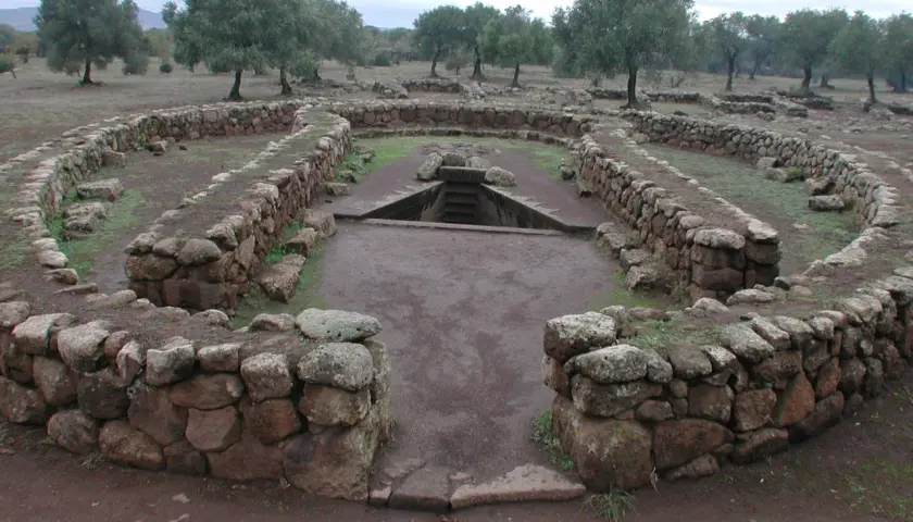Antichi pozzi sacri in Sardegna, con mura in pietra a secco e una scala che scende nell'acqua.