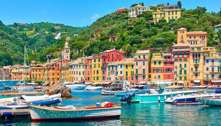 Portofino cosa vedere: case colorate, barche nel porto e colline verdi. Un incanto ligure.