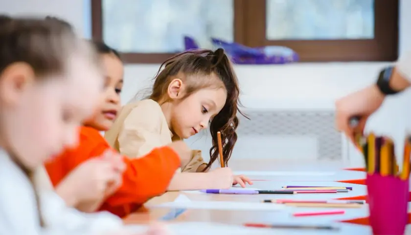 Bambini concentrati a disegnare, un esempio di scuola senza zaino pro e contro.
