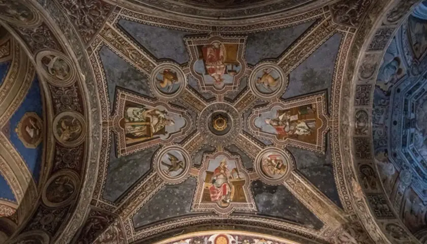 Volta affrescata di San Michele a Pavia, con scene bibliche e figure angeliche che adornano le volte a crociera, un capolavoro di arte medievale.