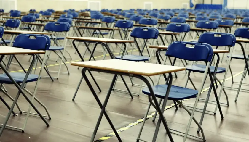 File di sedie e banchi vuoti in un'aula, pronti per le nuove classi di concorso.