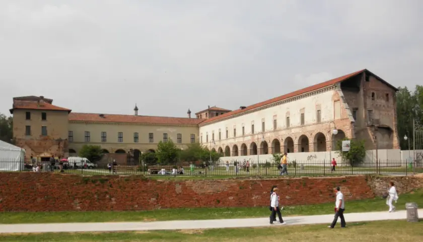 Il castello di Melegnano, con la sua architettura storica, accoglie visitatori e passeggiatori in una giornata nuvolosa.