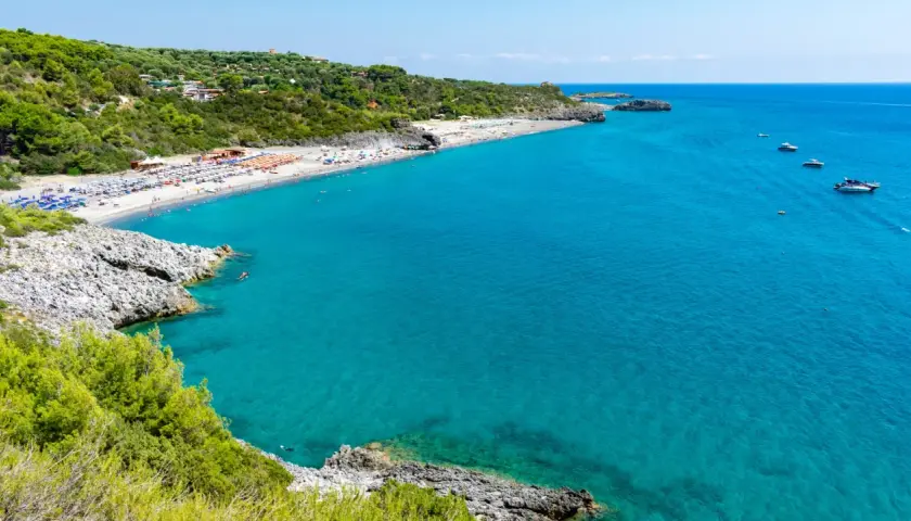 La spiaggia di Marina di Camerota, con il suo mare cristallino e la costa verdeggiante, invita al relax e al nuoto.