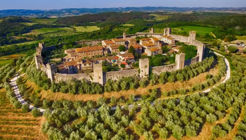 Un antico borgo fortificato domina la collina, circondato da uliveti e vigneti. Un gioiello tra i borghi toscana, immerso nel verde.