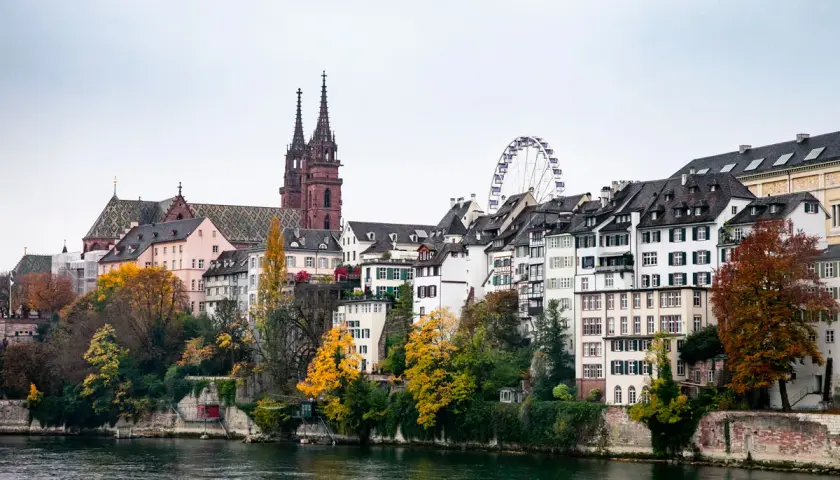 Basilea cosa vedere: la cattedrale con le torri gemelle, case colorate lungo il fiume Reno e la ruota panoramica.