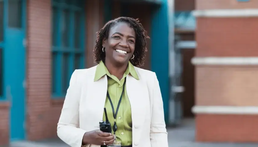 Donna sorridente con un walkie-talkie, pronta per il suo lavoro. Il suo dsga stipendio è meritato.