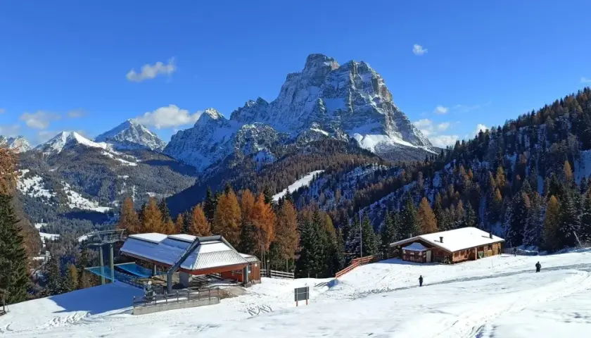 Paesaggio invernale con montagne innevate, boschi di larici e abeti, rifugi e un impianto di risalita. Ideale per il trekking in Cadore.