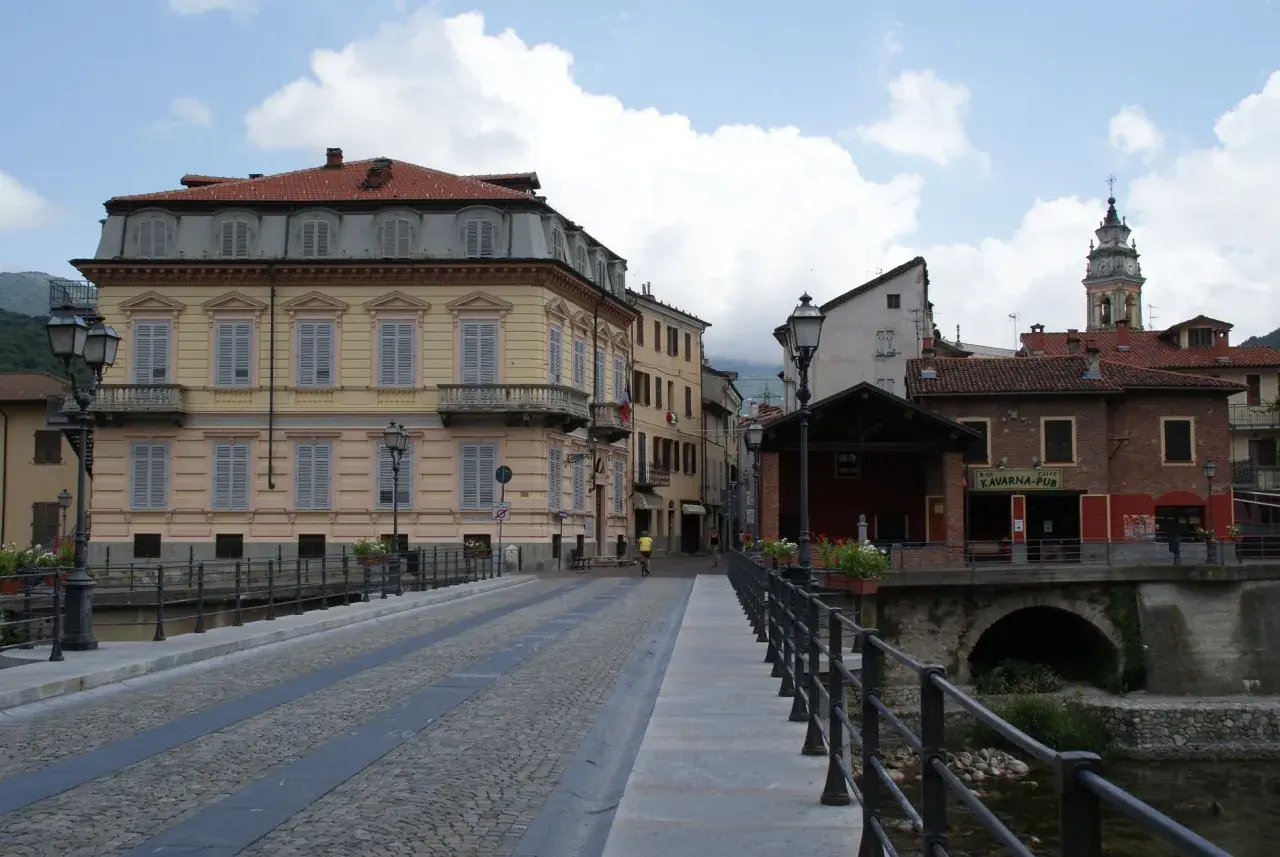 Ponte acciottolato a Garessio, con edifici storici e la torre dell'orologio che svetta. L'altitudine di Garessio offre scorci suggestivi.