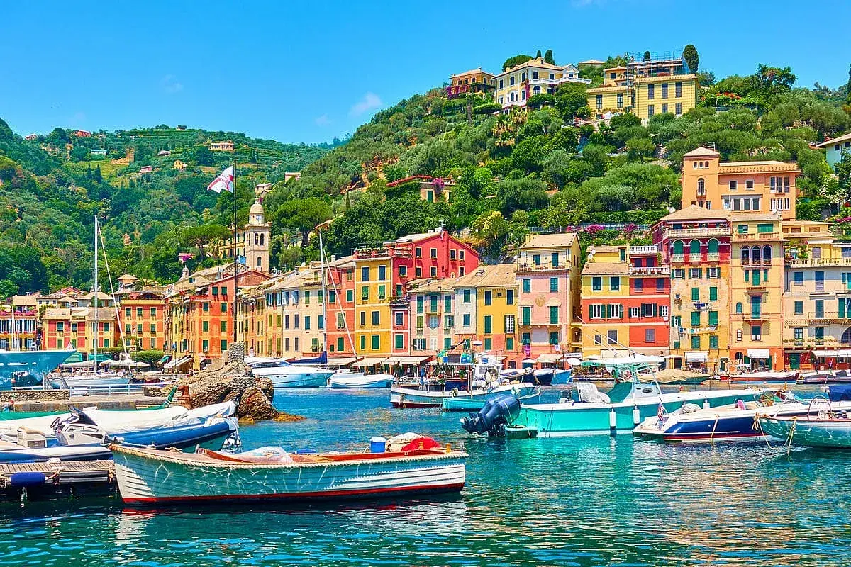 Portofino cosa vedere: case colorate, barche nel porto e colline verdi. Un incanto ligure.