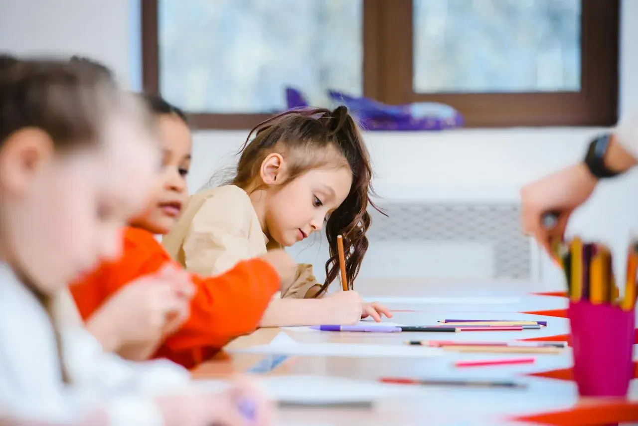 Bambini concentrati a disegnare, un esempio di scuola senza zaino pro e contro.