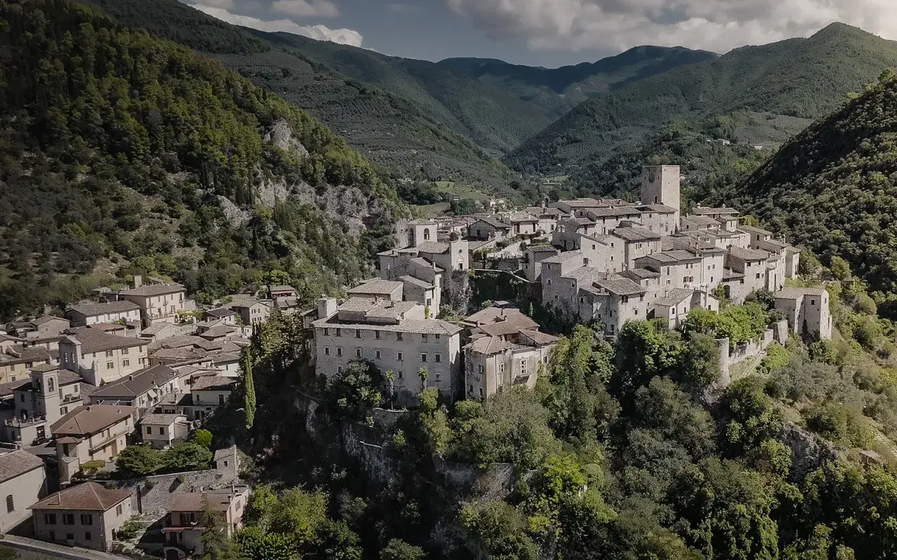 Borgo medievale di Arrone, Terni, incastonato tra verdi colline. Case in pietra e un'antica torre dominano il paesaggio.
