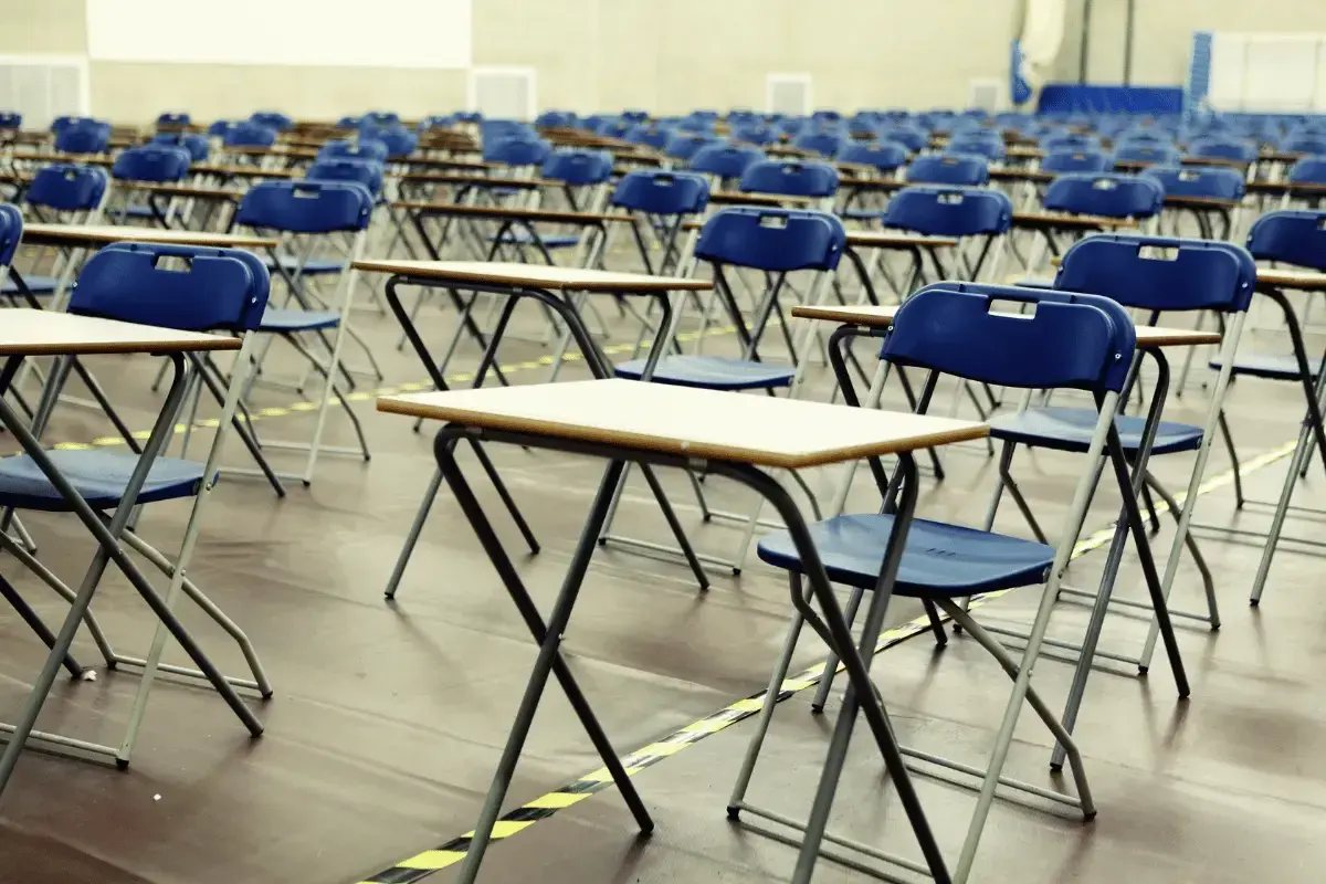 File di sedie e banchi vuoti in un'aula, pronti per le nuove classi di concorso.