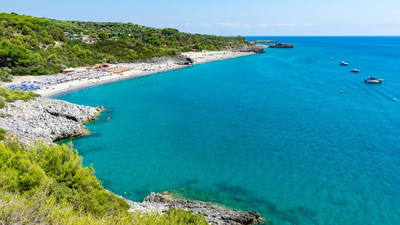 La spiaggia di Marina di Camerota, con il suo mare cristallino e la costa verdeggiante, invita al relax e al nuoto.