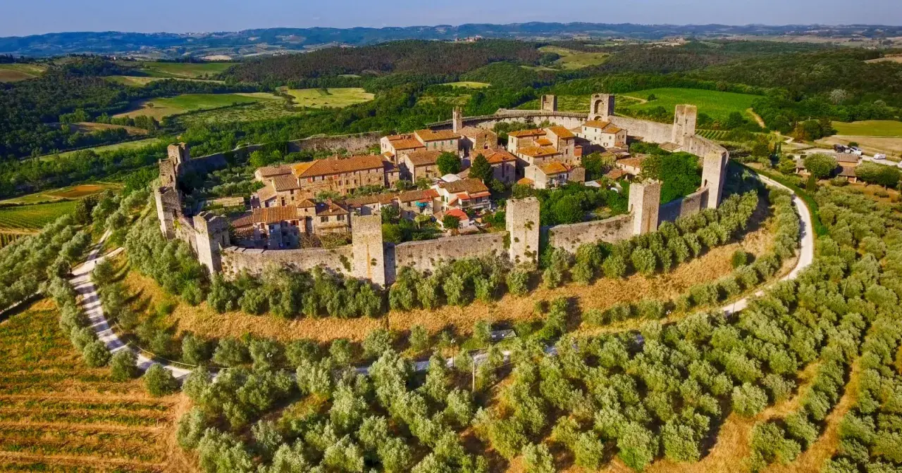 Un antico borgo fortificato domina la collina, circondato da uliveti e vigneti. Un gioiello tra i borghi toscana, immerso nel verde.