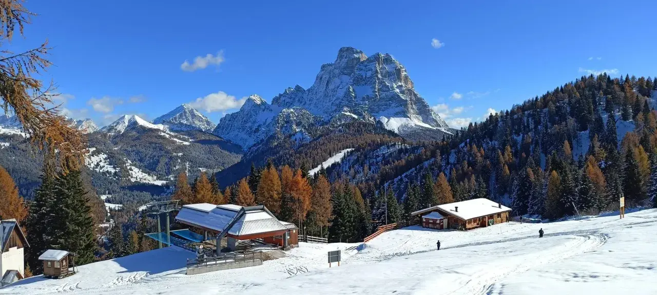 Paesaggio invernale con montagne innevate, boschi di larici e abeti, rifugi e un impianto di risalita. Ideale per il trekking in Cadore.