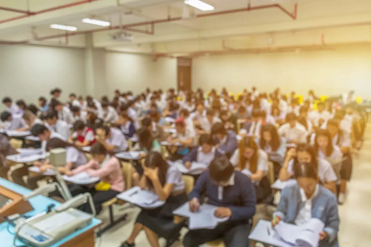 Aula universitaria affollata, studenti concentrati sugli esami. Il sfp significato università è la chiave per il loro futuro.
