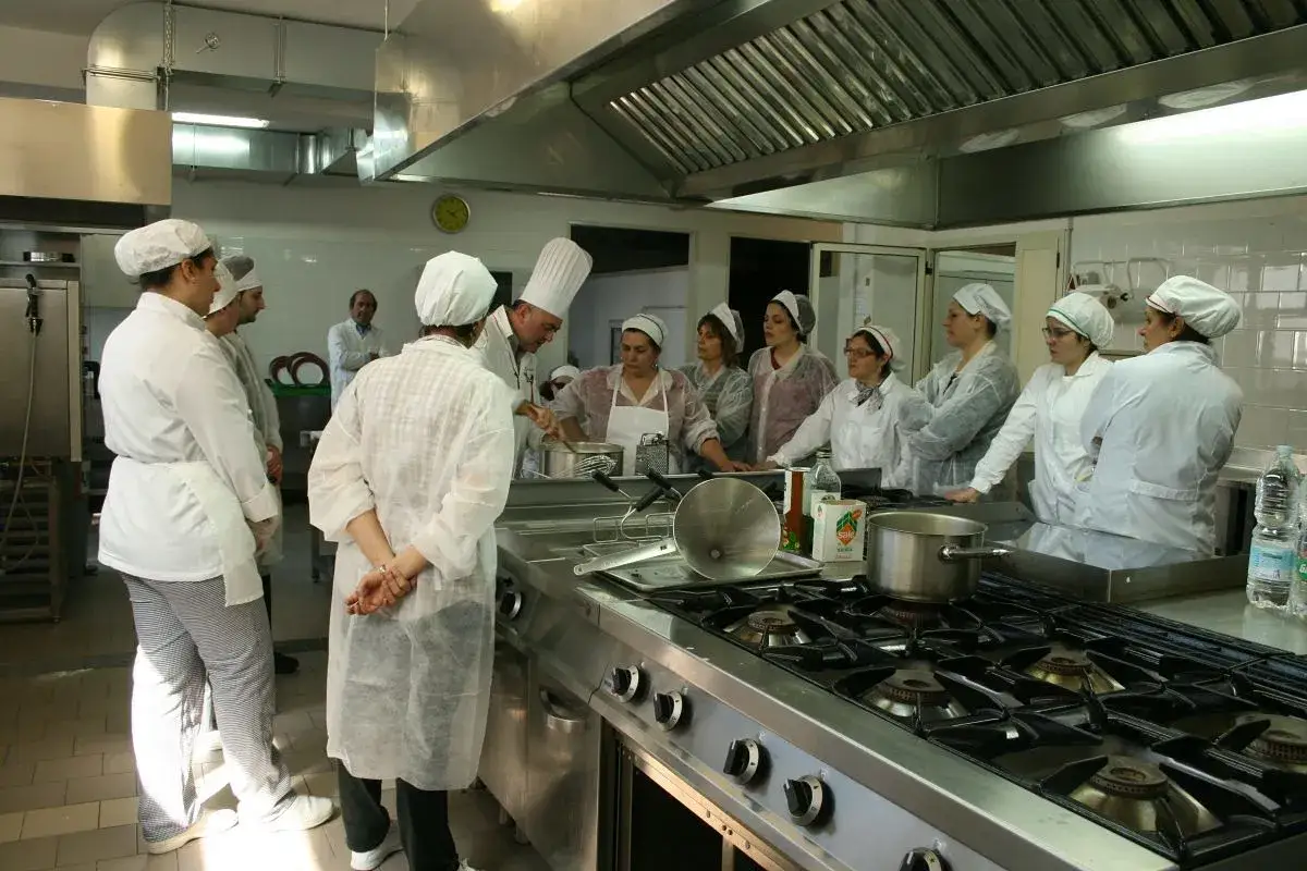 Studenti e chef in cucina all'istituto alberghiero Santa Cesarea Terme imparano a cucinare.