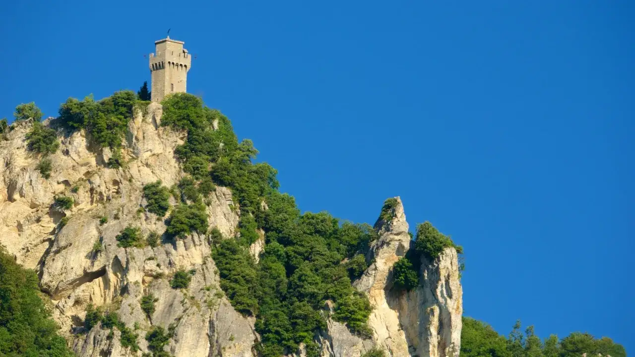Torre medievale su una roccia scoscesa, un invito a visitare San Marino per ammirare panorami mozzafiato.
