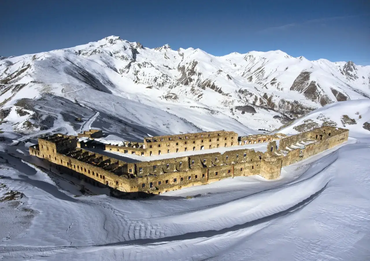 Fortezza in rovina a Limone Piemonte, circondata da montagne innevate. Un luogo suggestivo da esplorare, tra i tesori da vedere in Piemonte.