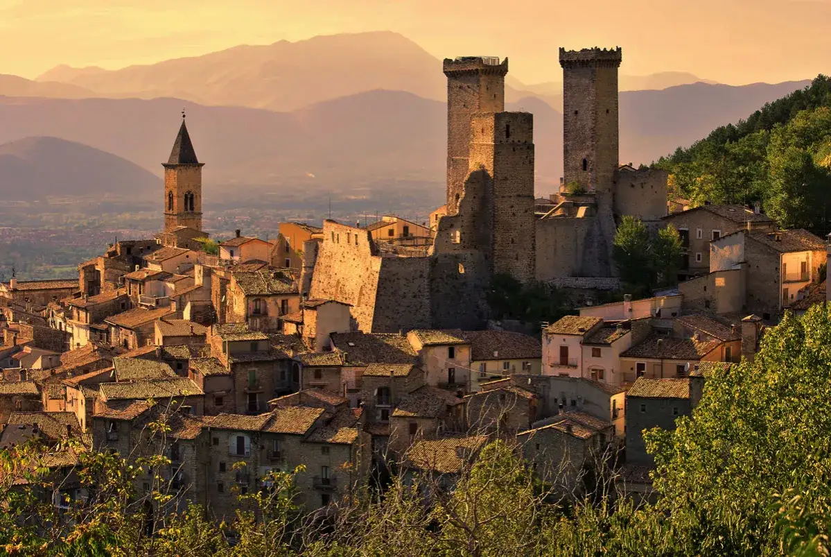 Borgo medievale con torri imponenti e case in pietra, ideale per chi ama visitare Abruzzo itinerari storici al tramonto.
