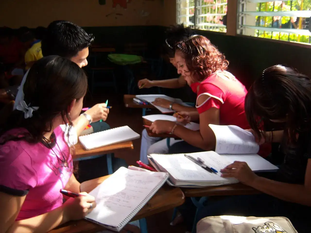 Studenti concentrati su appunti e libri, un esempio di progettazione didattica attiva in classe.