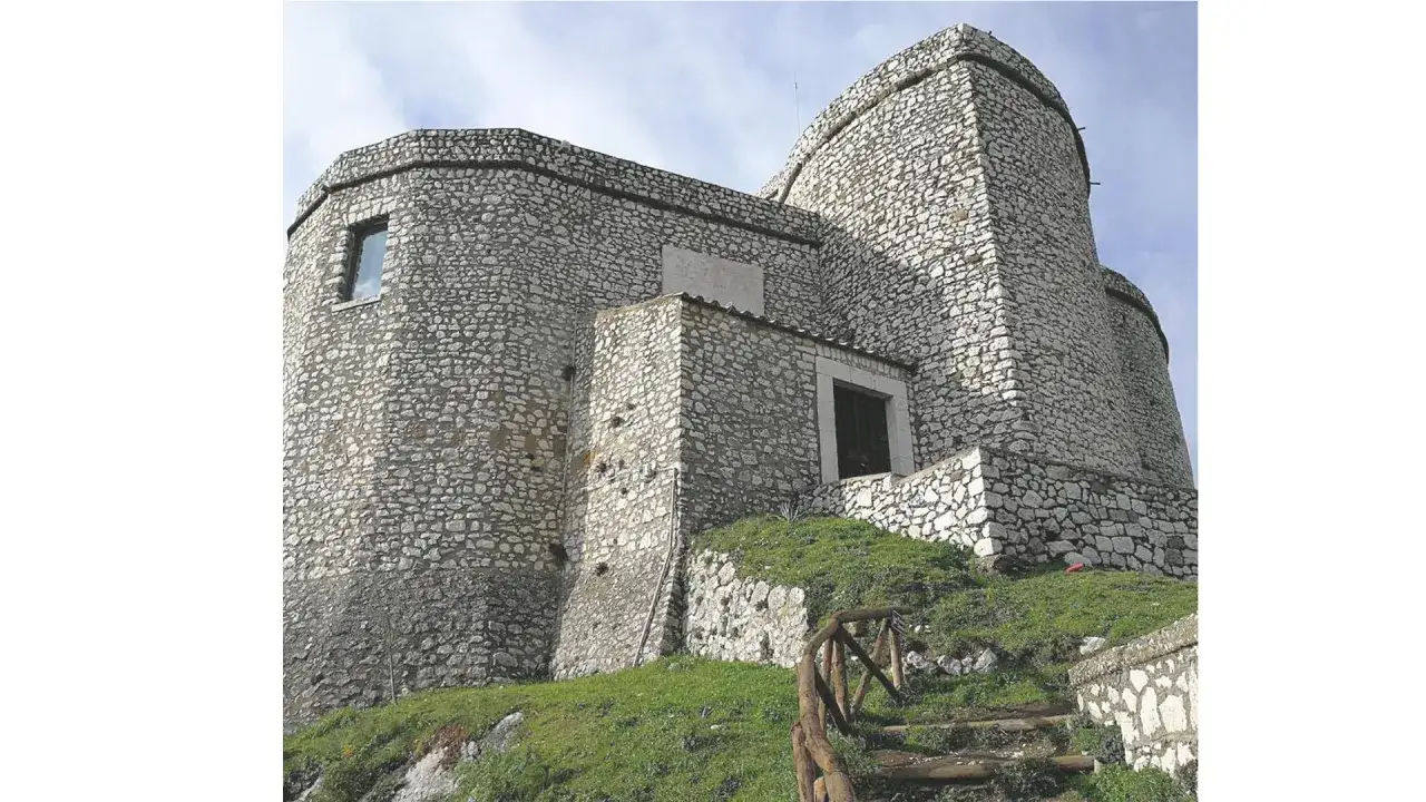 Castello di Montesarchio, Benevento. Imponente fortezza in pietra con torri arrotondate e un sentiero in legno che sale verso l'ingresso.