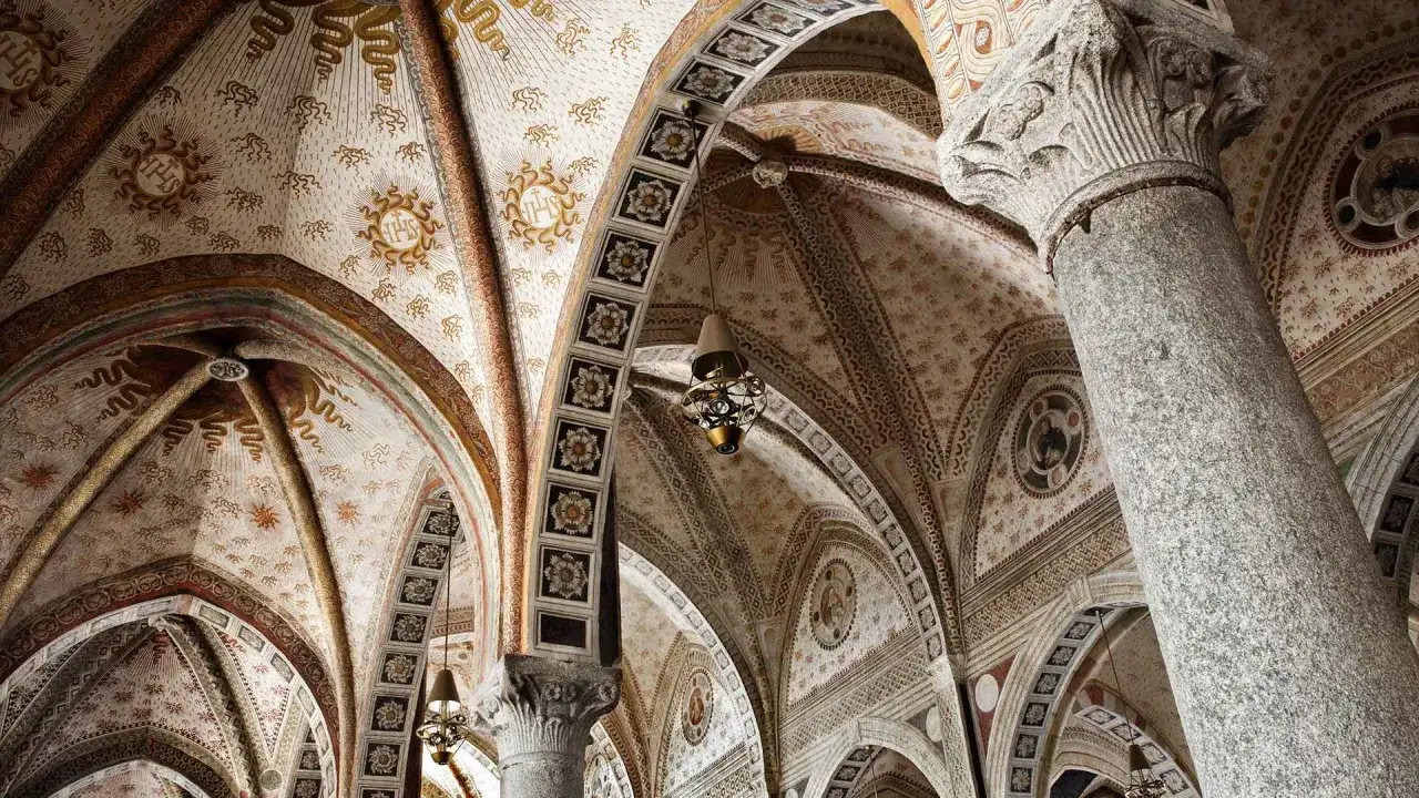 Volte affrescate e decorate con simboli sacri all'interno di Santa Maria delle Grazie. Colonne imponenti sorreggono archi slanciati.